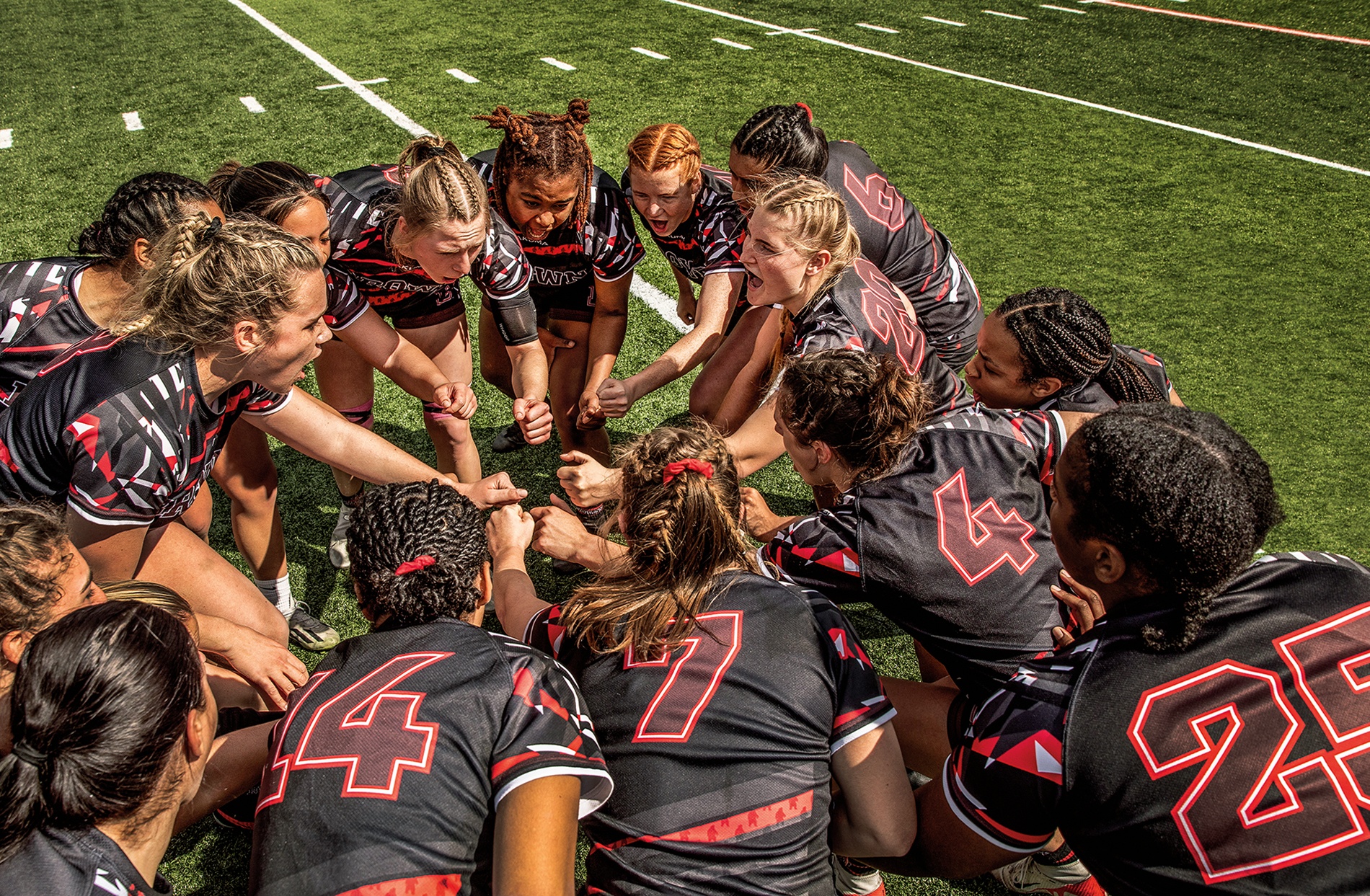 photo of the Brown women's Rugby Team huddling during a game